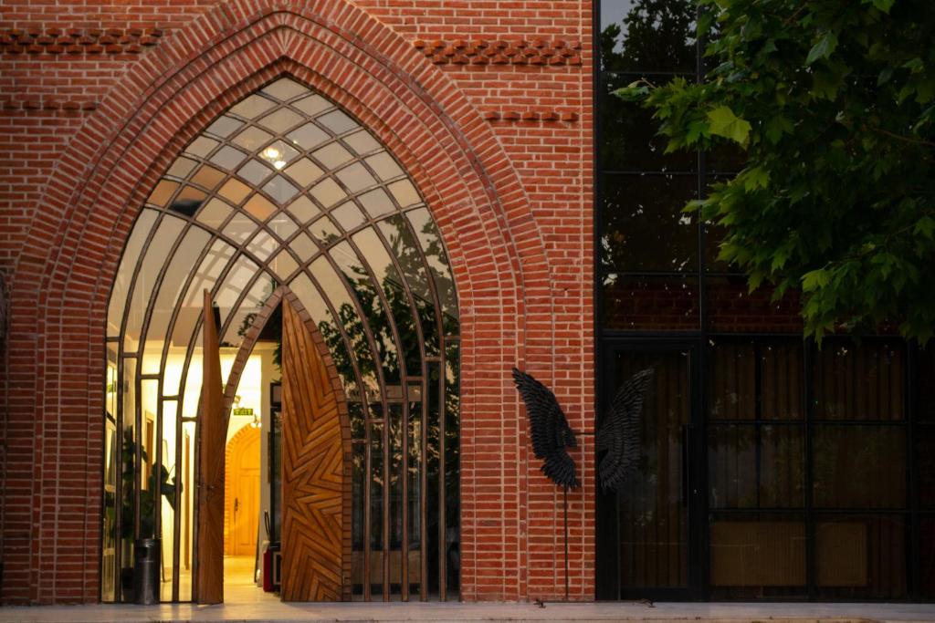 ein Eingang zu einem Backsteingebäude mit offener Tür in der Unterkunft Citadel 360 Suites & Spa in Skopje