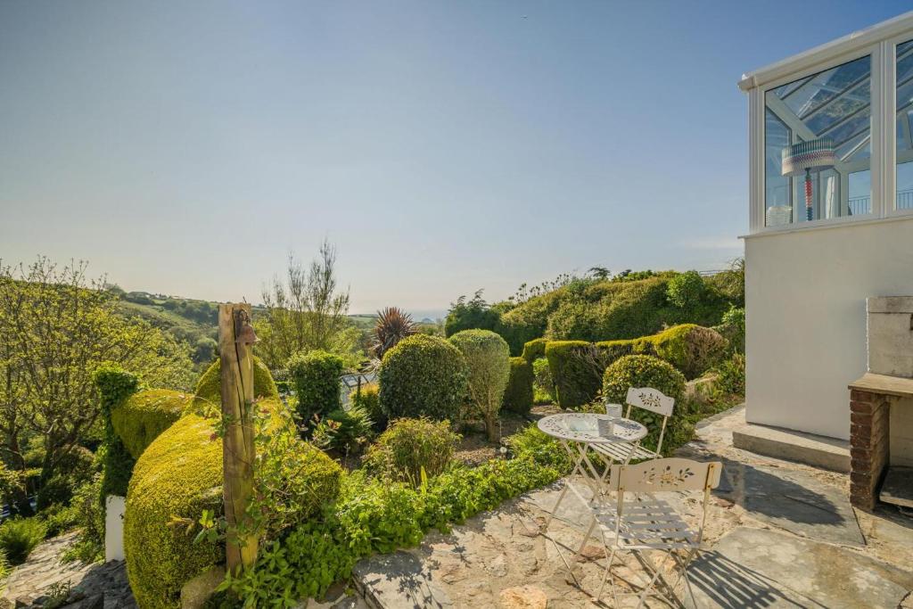 a garden ofxus spheres with a table and chairs at 3 Bed in Tintagel oc-trev5 in Treknow