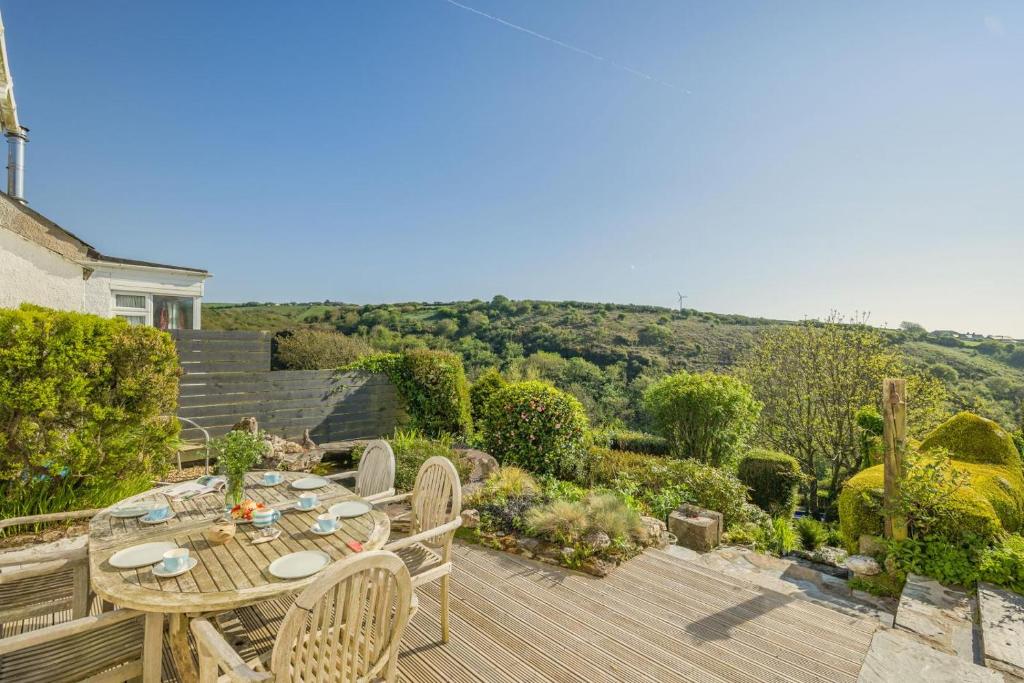 a patio with a table and chairs on a wooden deck at 4 Bed in Tintagel oc-trev in Treknow