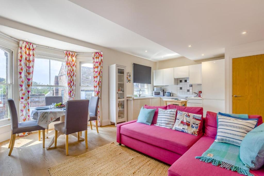 a living room with a pink couch and a kitchen at 1 Bed in Southwold oc-bate in Southwold