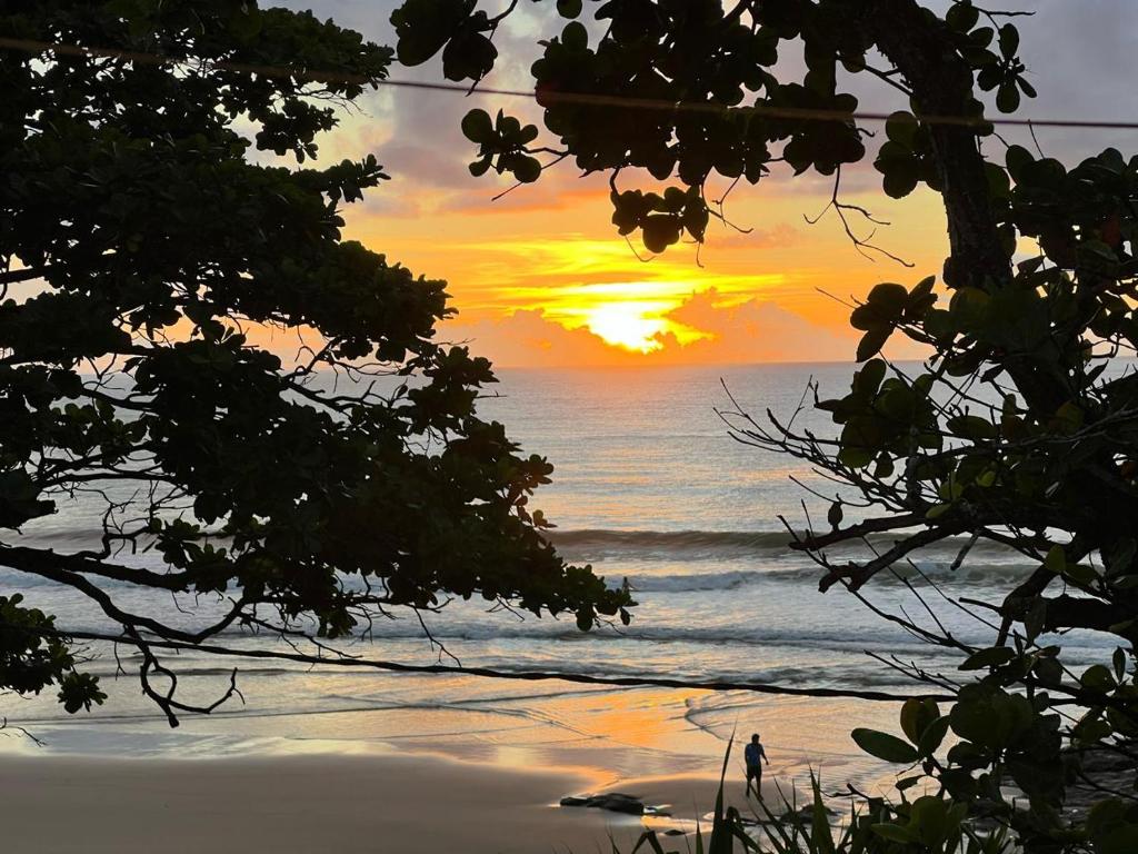 a sunset over a beach with the ocean at Pousada Tiririca Surf in Itacaré