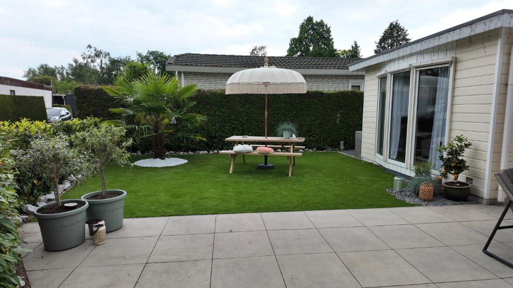 a backyard with a table and an umbrella at ViVe in Putten