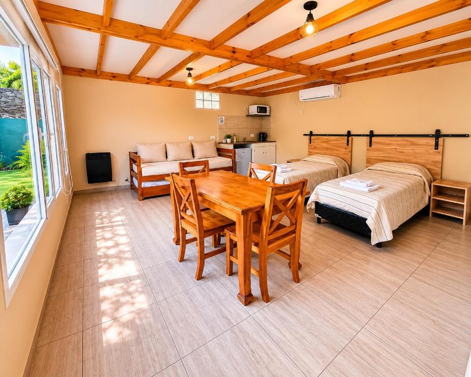 a living room with two beds and a table at Las lupinas pleno centro in Coronel Suárez