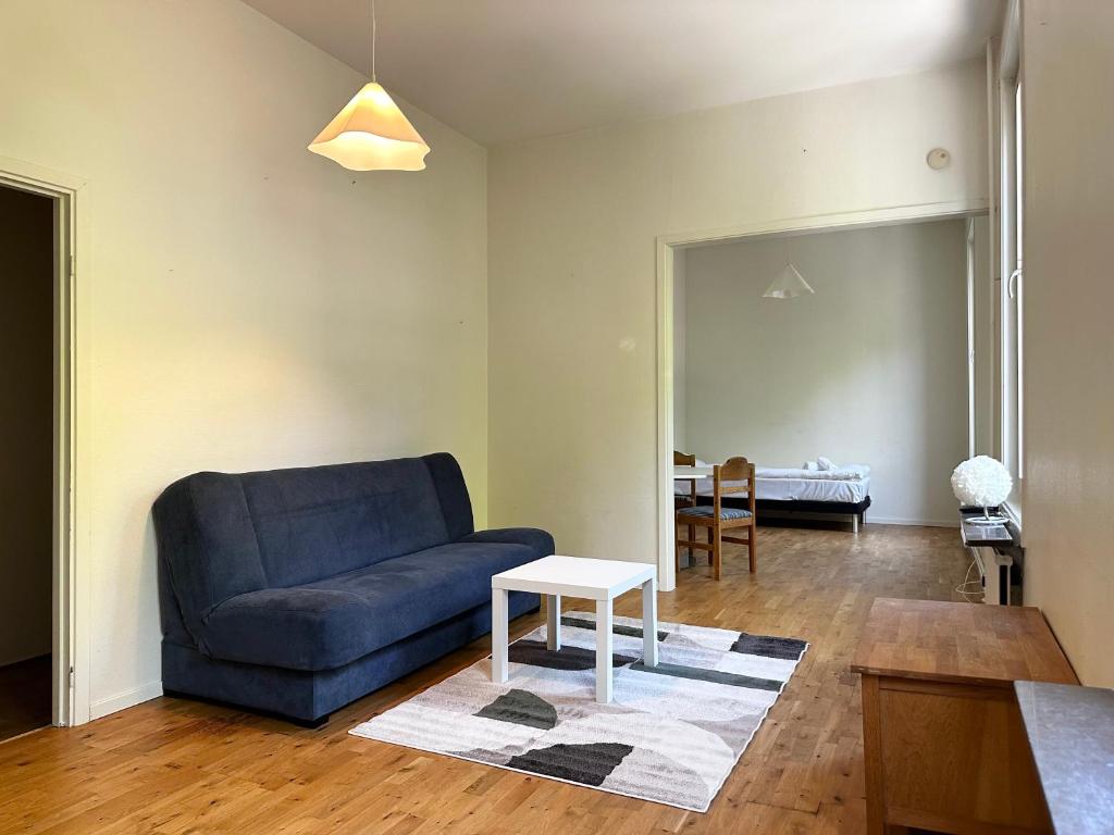 a living room with a blue couch and a table at Apartment Centrum Karlshamn in Karlshamn