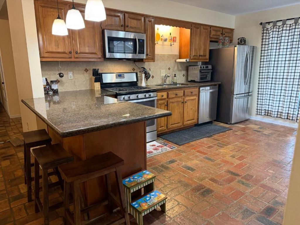 a kitchen with wooden cabinets and a stainless steel refrigerator at WildFlower Inn in Satsuma