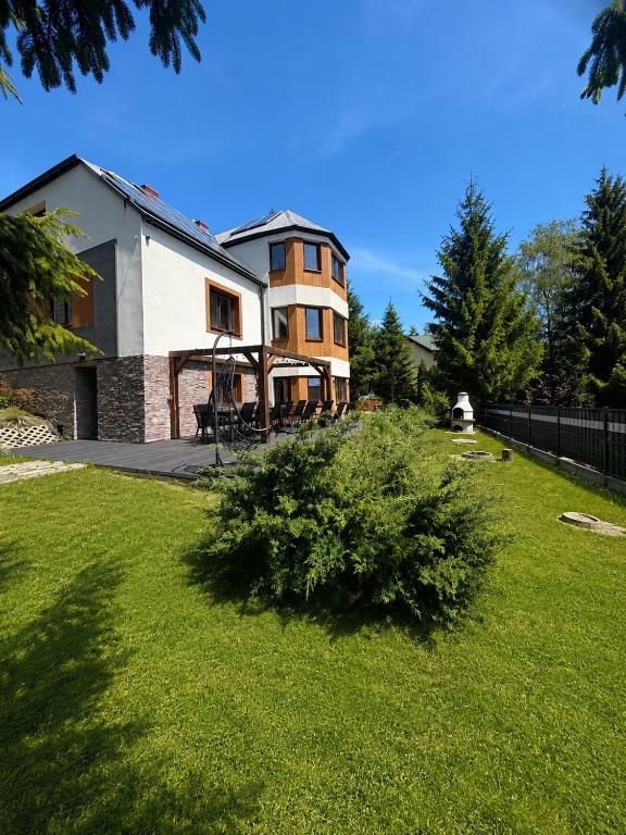a house in a yard with a green lawn at Istebna Pełna Chata II in Istebna