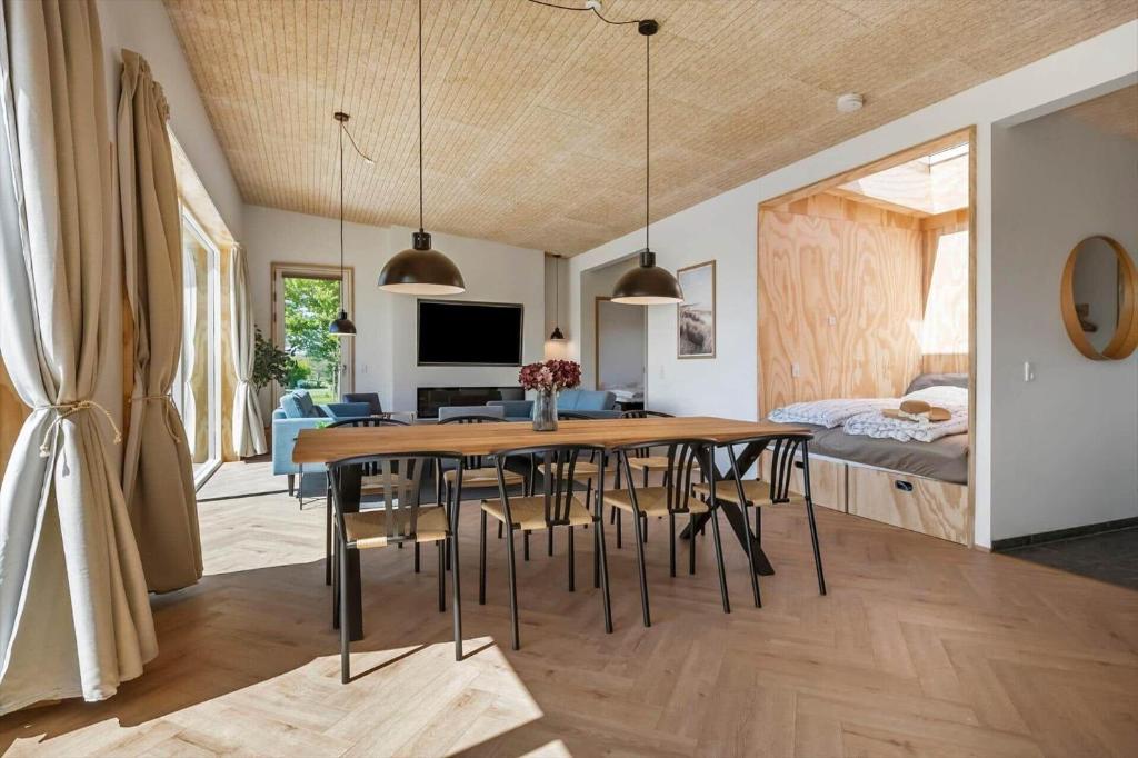 a dining room and living room with a table and chairs at 30433-Saksild-Strand-Odder-Strandlodden-2 in Rude