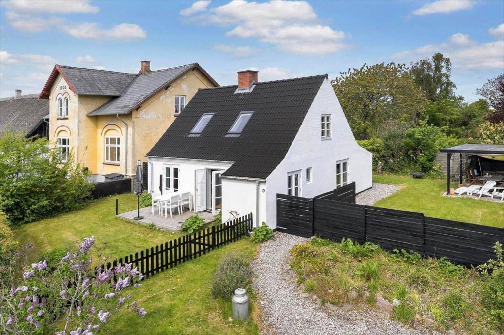 a large white house with a black roof at 20623-Samso-Besser-Hovedgade-9 in Besser