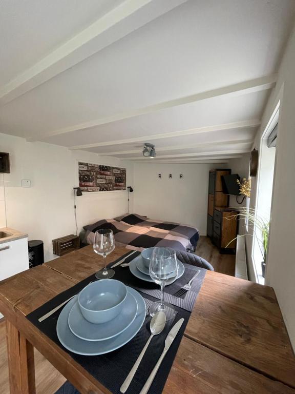 a dining room table with two plates and wine glasses at B&Beach Zandvoort in Zandvoort
