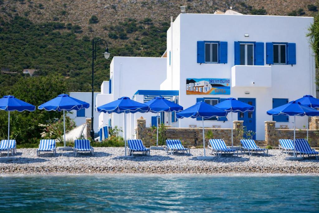 a group of blue chairs and umbrellas on a beach at Dream Island Hotel in Livadia