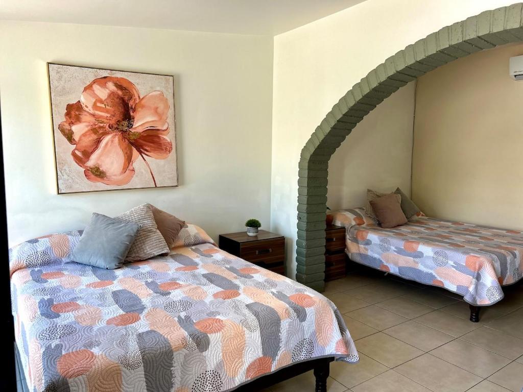 a bedroom with two beds and an archway at Estudio #2 a 5 min del malecon in La Paz