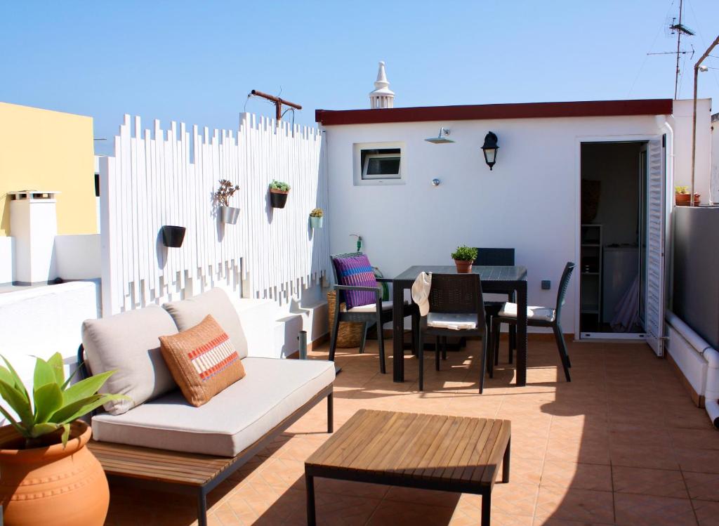 a patio with a white fence and a table and chairs at Townhouse with Rooftop Terrace in Olhão in Olhão