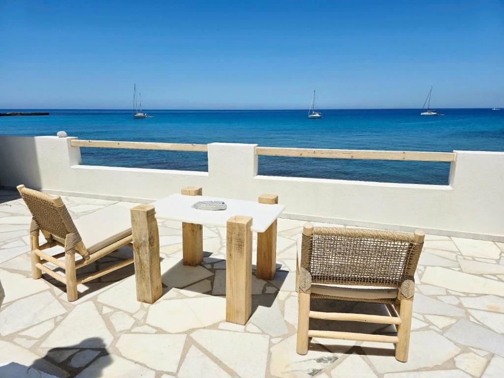 a table and chairs on a patio overlooking the ocean at Ma mer in Naxos Chora