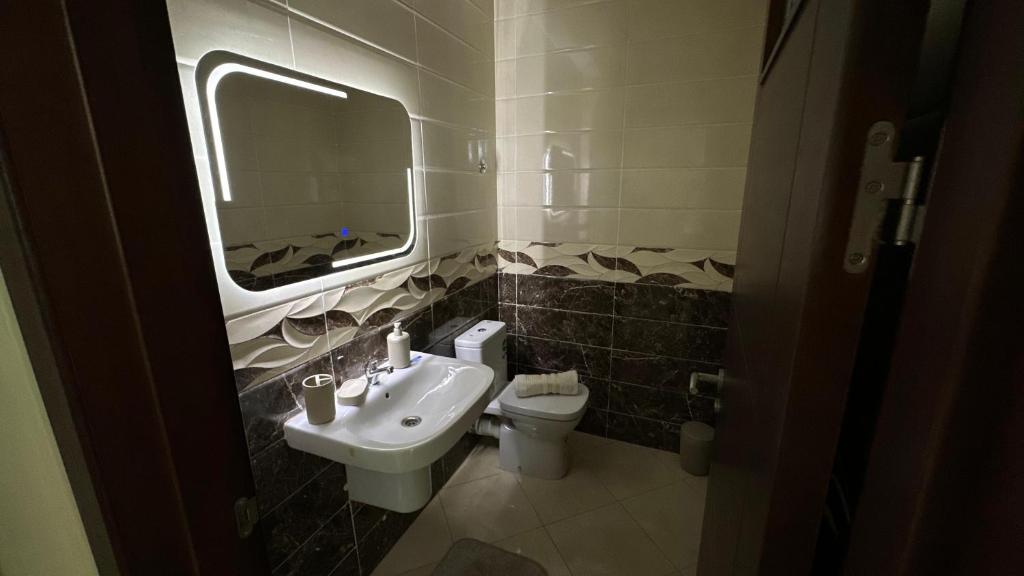 a bathroom with a sink and a toilet and a mirror at Appartement cosy in Agadir
