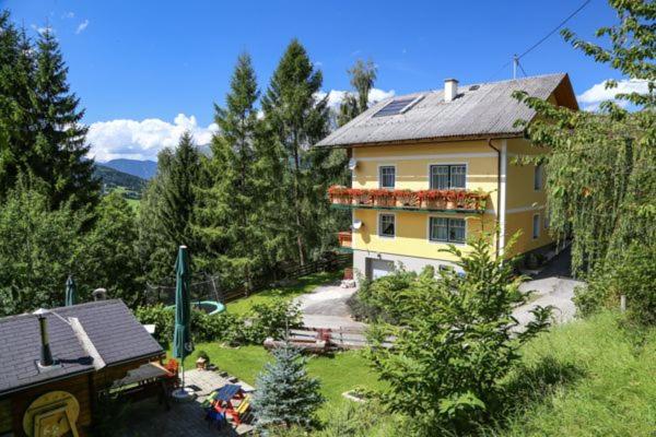 a large yellow house in the middle of a yard at Haus Weisl in Erlsberg