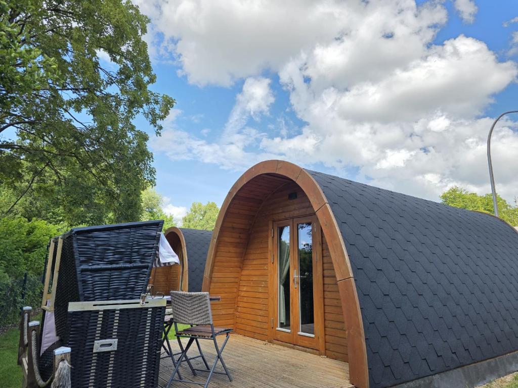 a small wooden house with a wooden deck at 06 Premium Camping Pod "Habel" in Silberstedt