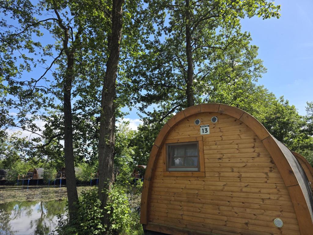 a small wooden cabin in the middle of a river at 13 Premium Camping Pod "Holmer See" in Silberstedt