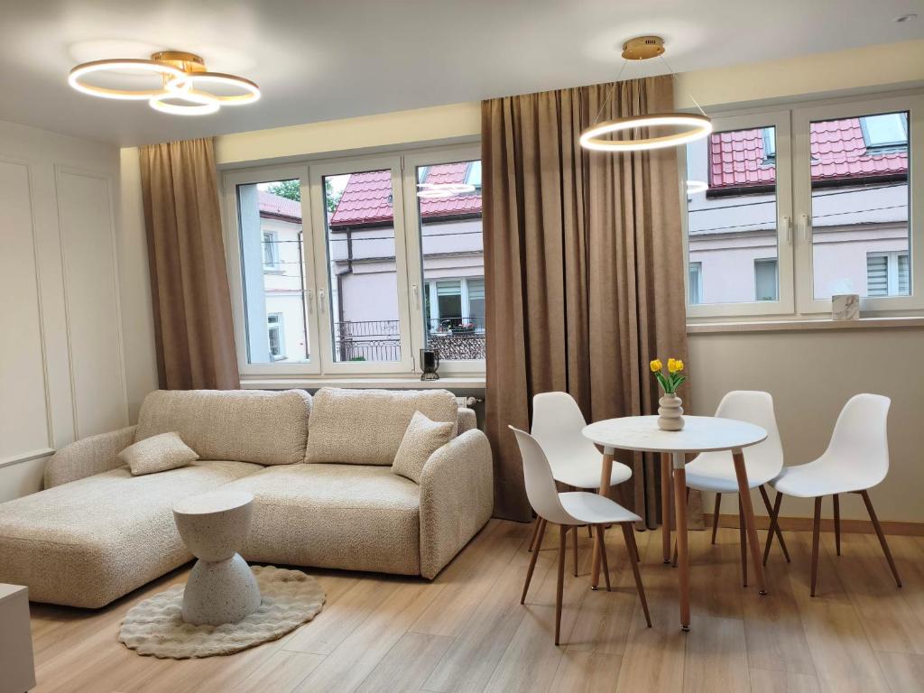 a living room with a couch and a table and chairs at Apartament Krótka in Łomża