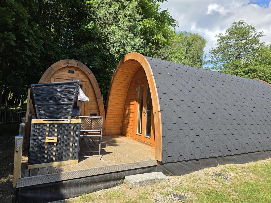 a small wooden house with a wooden deck at 00 Familien Premium Pods "Ebbe" in Silberstedt