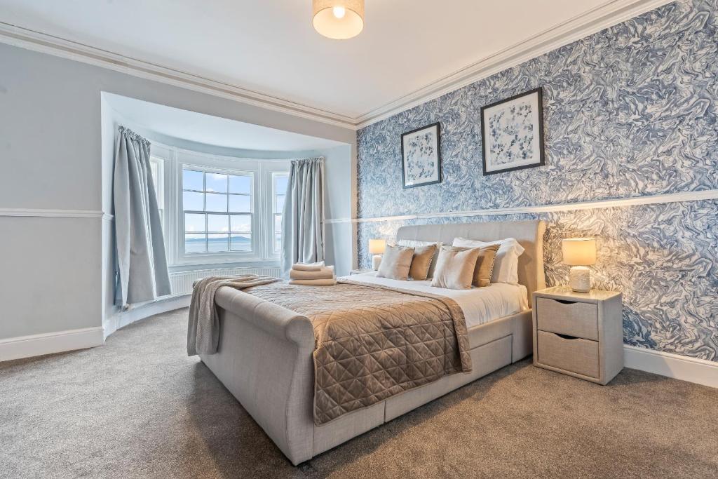 a bedroom with a large bed with blue wallpaper at Bay Apartment 2 in Morecambe