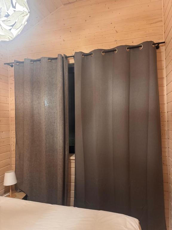 a bedroom with gray curtains and a bed at Gubławki Resort in Gubławki