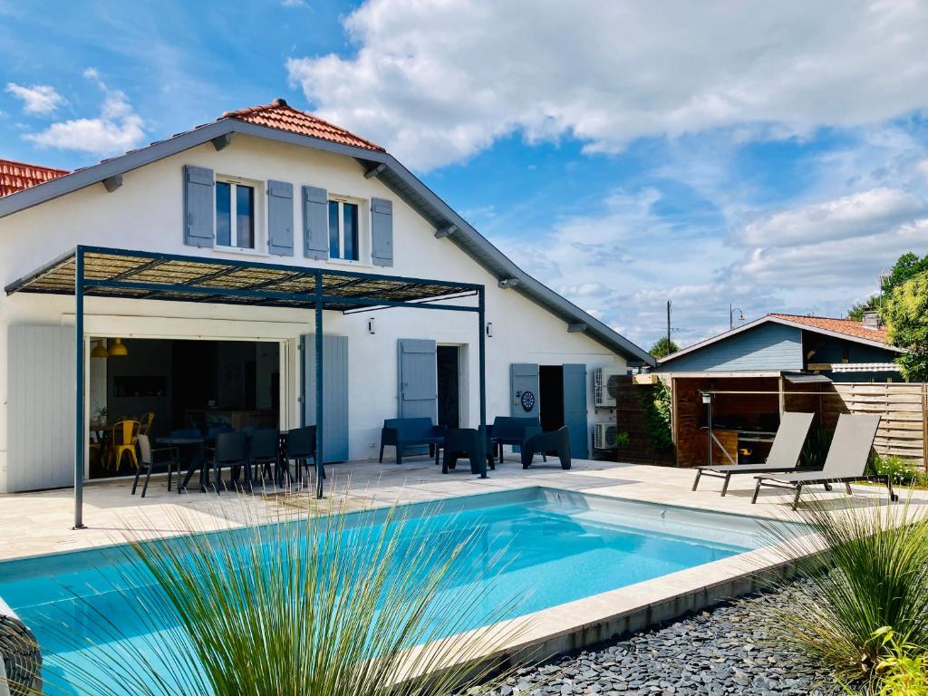 a house with a swimming pool in front of a house at Chai Nous - votre villa au cœur des Landes - classée 4 étoiles in Rion-des-Landes