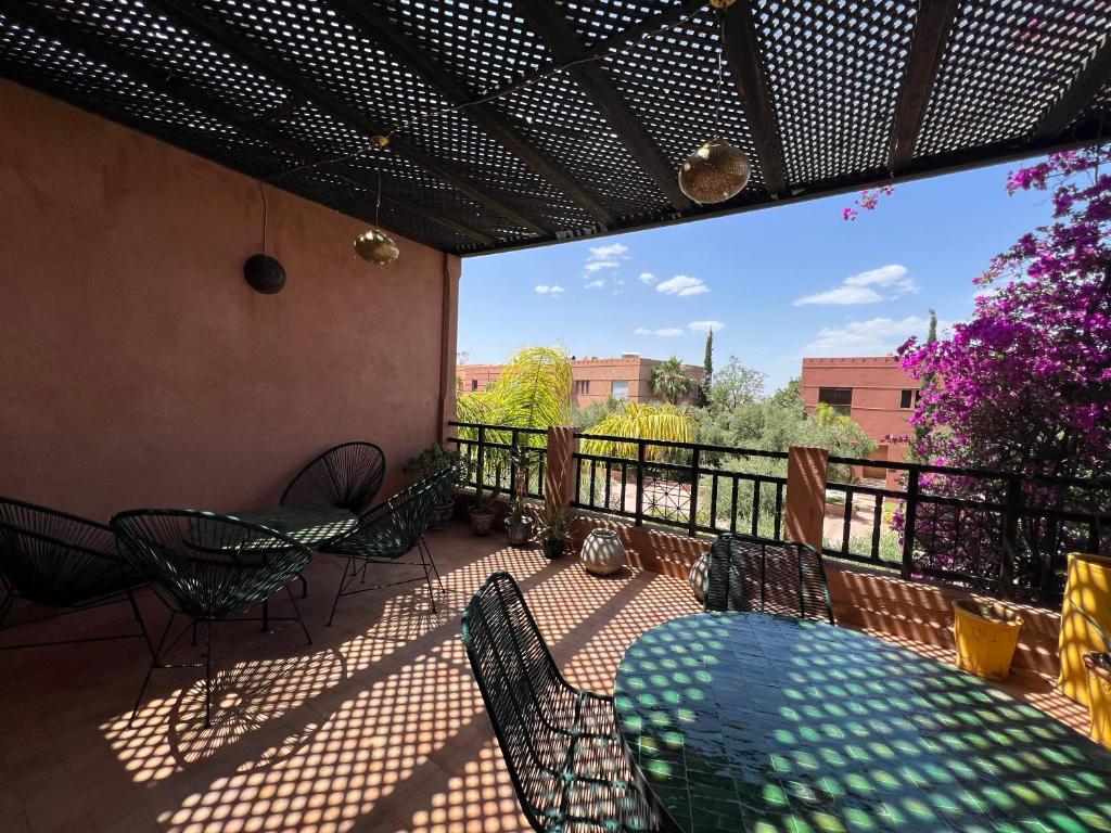 a patio with a table and chairs on a balcony at Resort Apartment Golf View in Marrakesh