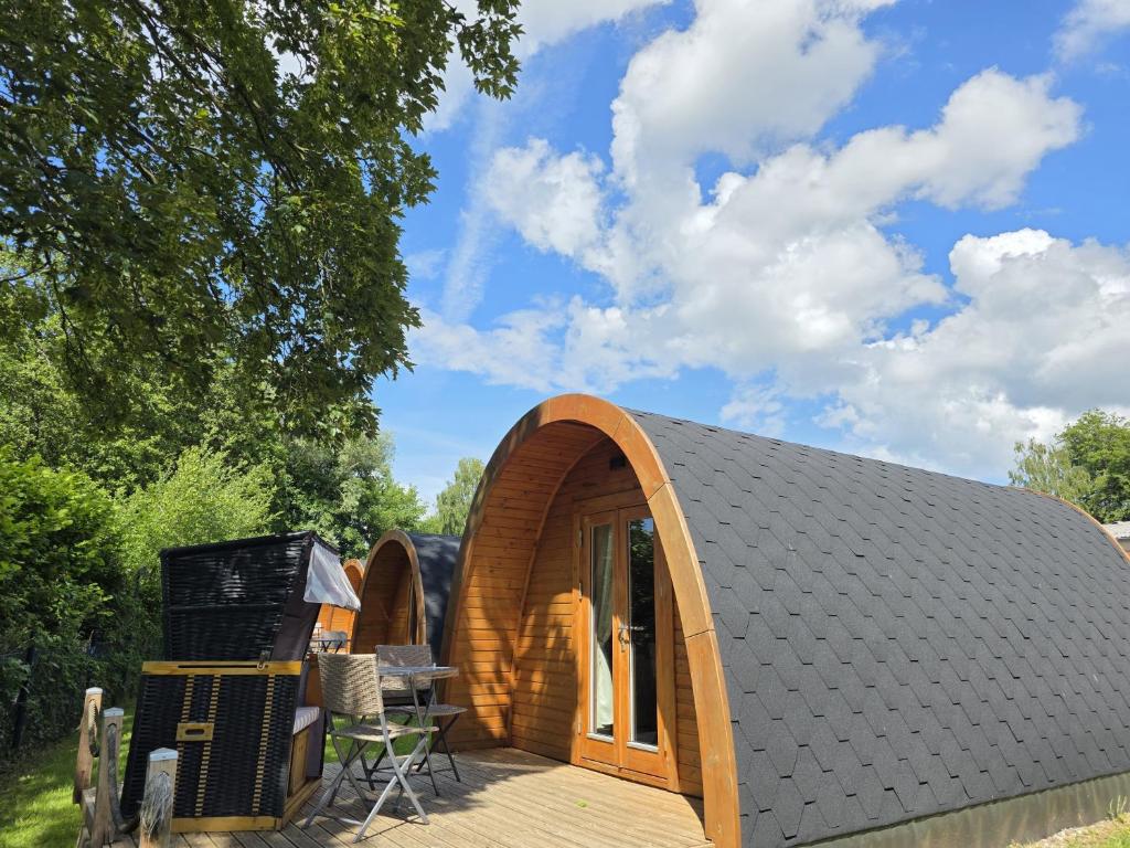 a small wooden cabin with a wooden deck at 05 Premium Camping Pod "Gröde" in Silberstedt