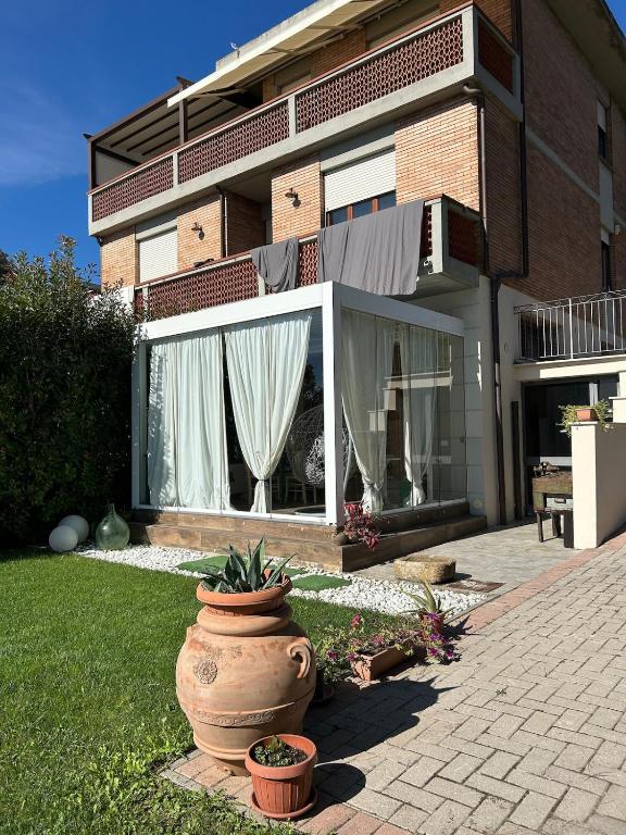 a house with a large vase in the yard at Casa di Piera in Poggibonsi