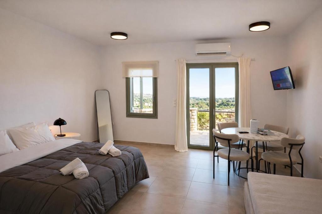 a bedroom with a bed and a table with chairs at Aroniadika rooms in Kythira