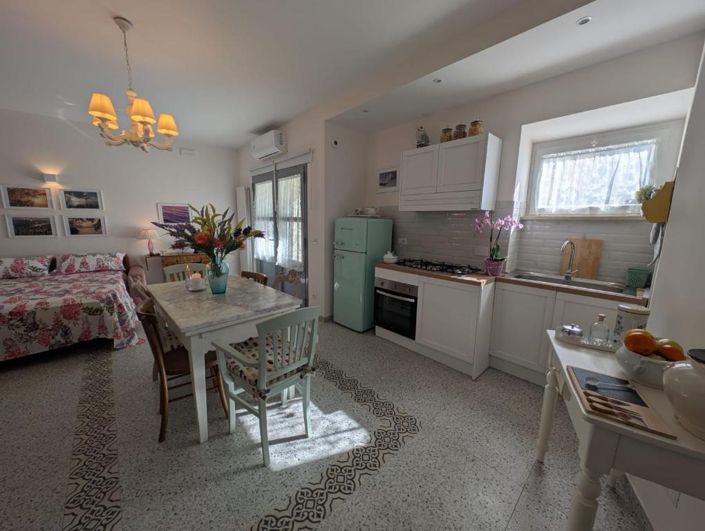 a kitchen with a table and a green refrigerator at Casa Mita - accogliente monolocale nel cuore del paese in Marta