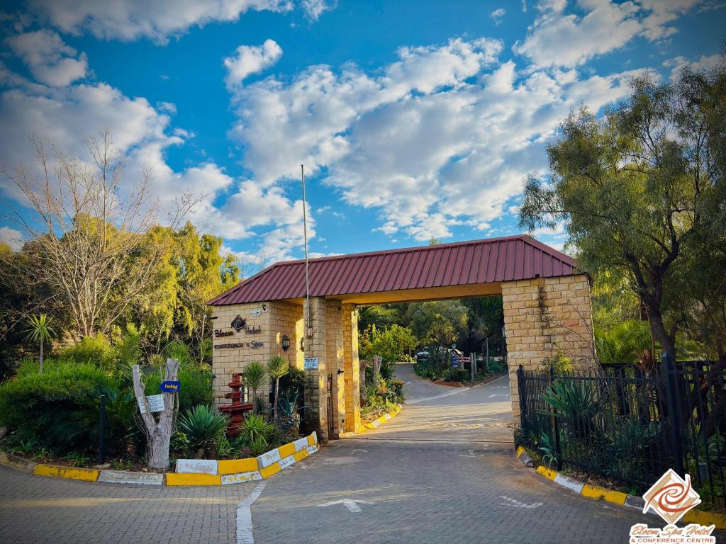 a brick building with a red roof on a road at Bloem Spa Hotel & Conference in Bloemfontein