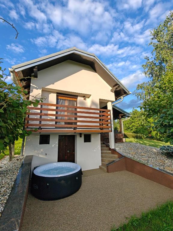 a small house with a balcony and a pool at Počitniška hiša Kuferland in Dobrovnik