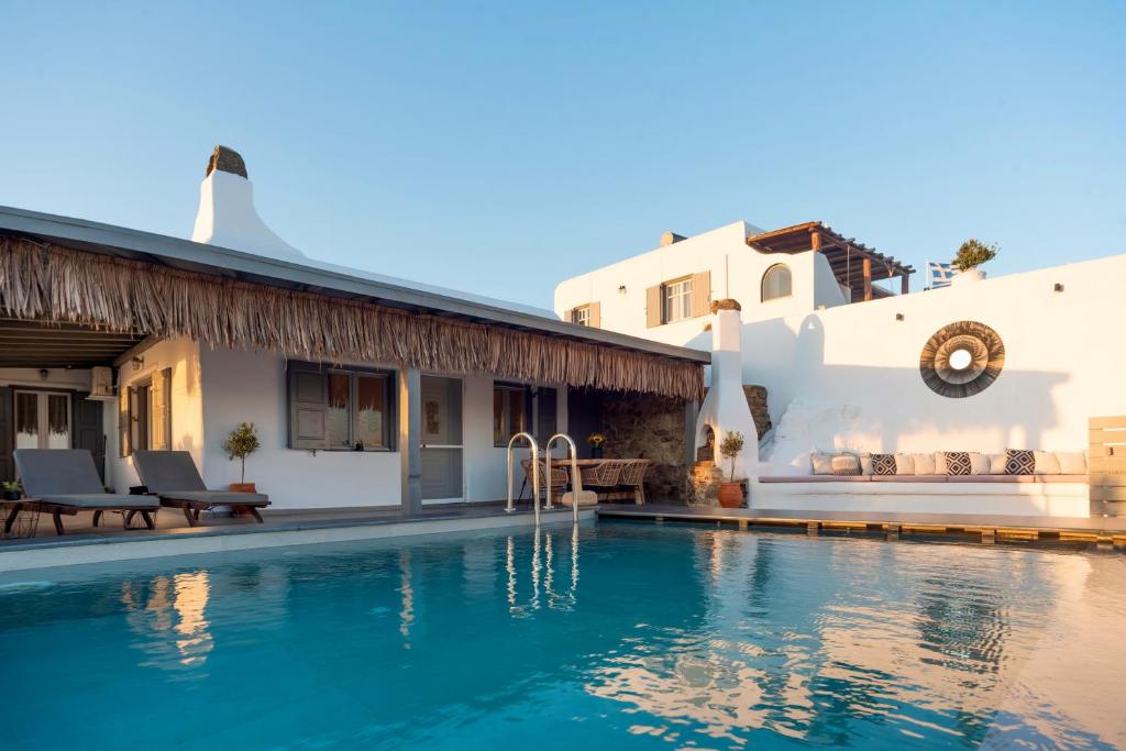 a villa with a swimming pool in front of a house at Infinity View Villas Mykonos in Kalo Livadi