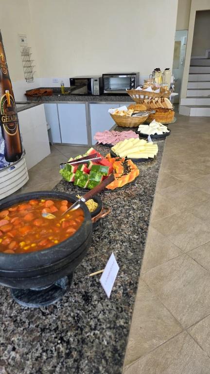 a buffet with bowls of food on a counter at Pousada Serra do Sol in Mariana