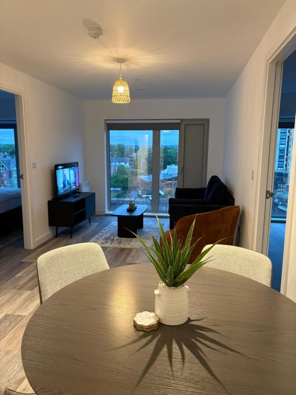 a living room with a table and chairs and a television at Modern 2BD 2 bathroom apartment close to city centre in Manchester