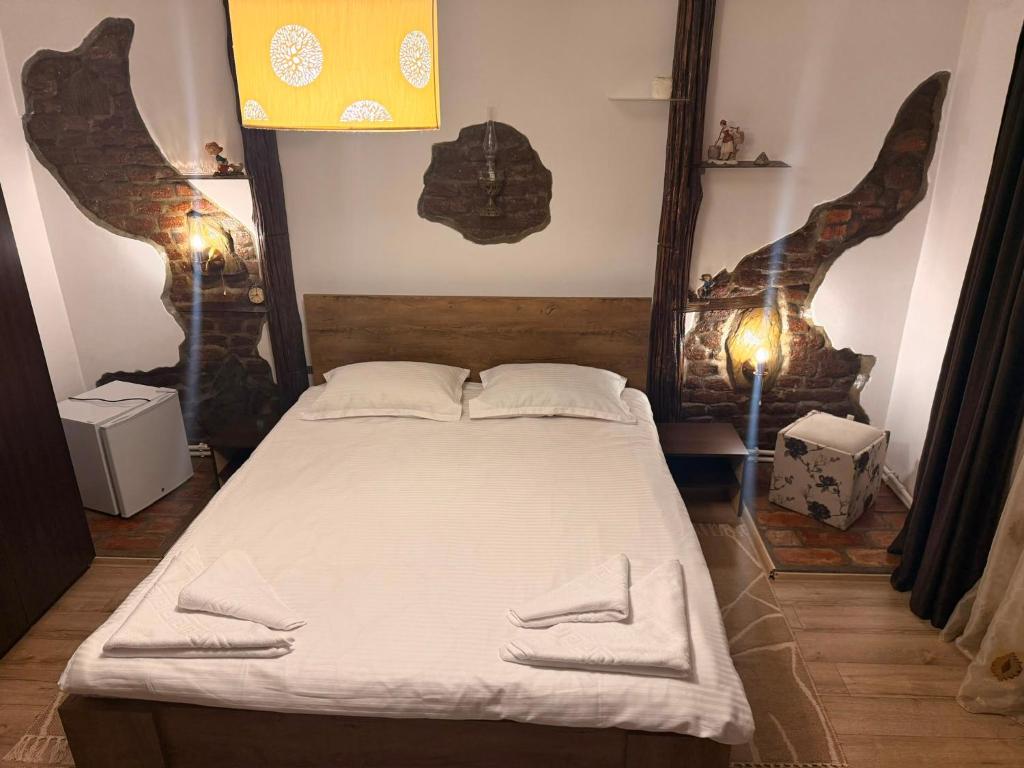 a bedroom with a bed with two towels on it at Casa Cosmin in Dobra