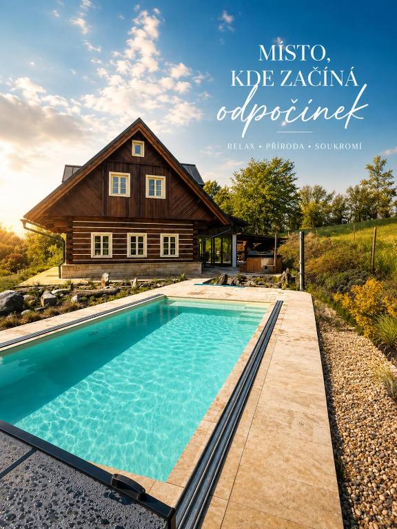 a house with a swimming pool in front of a house at Roubenka Pastvina in Rudník