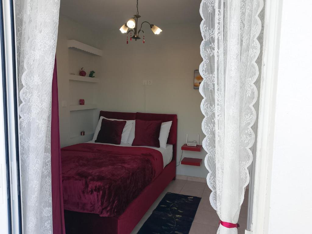a bedroom with a bed with a red comforter at Heavenly joy in Patra