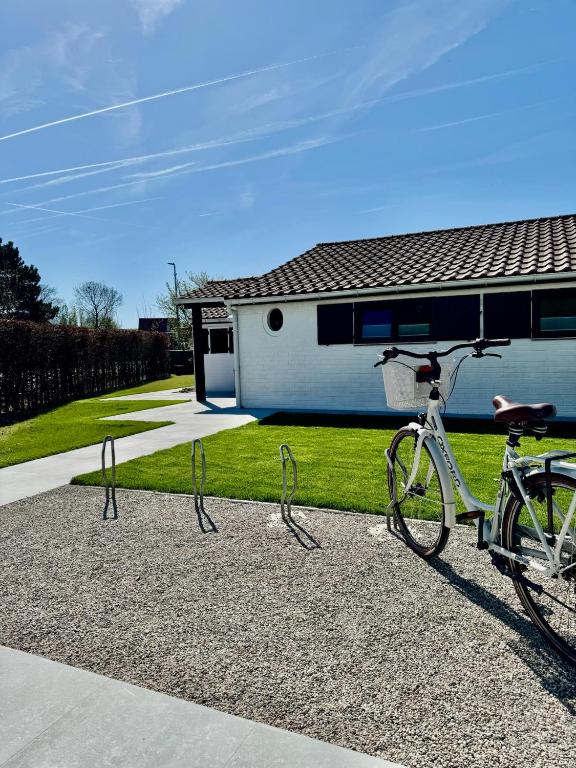 a bike parked in front of a house at Cozy Beach Home in De Haan
