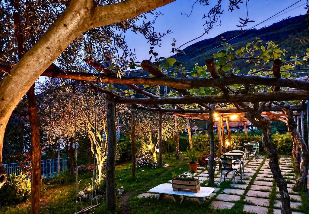a wooden pergola with a table and a bench at Mon Reve 2 in Pianillo
