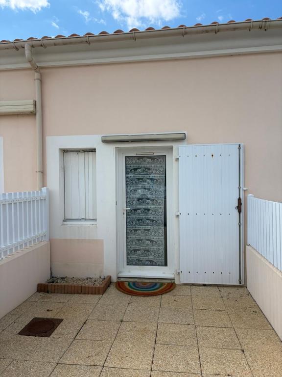 a white garage with a door on the side of a building at 225 rue de la source in Bretignolles-sur-Mer