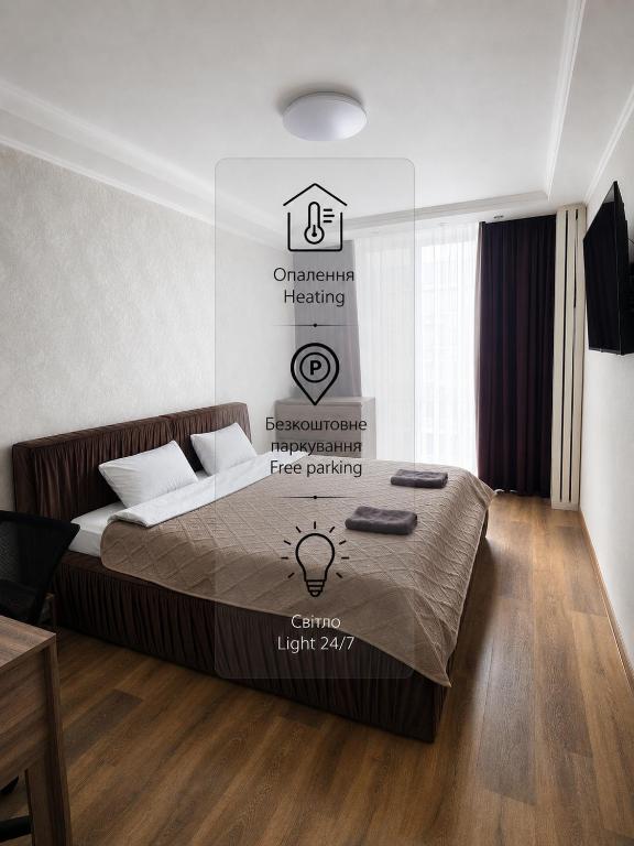a bedroom with a bed with a sign on the wall at Однокімнатні апартаменти в новому ЖК in Vasylʼkiv