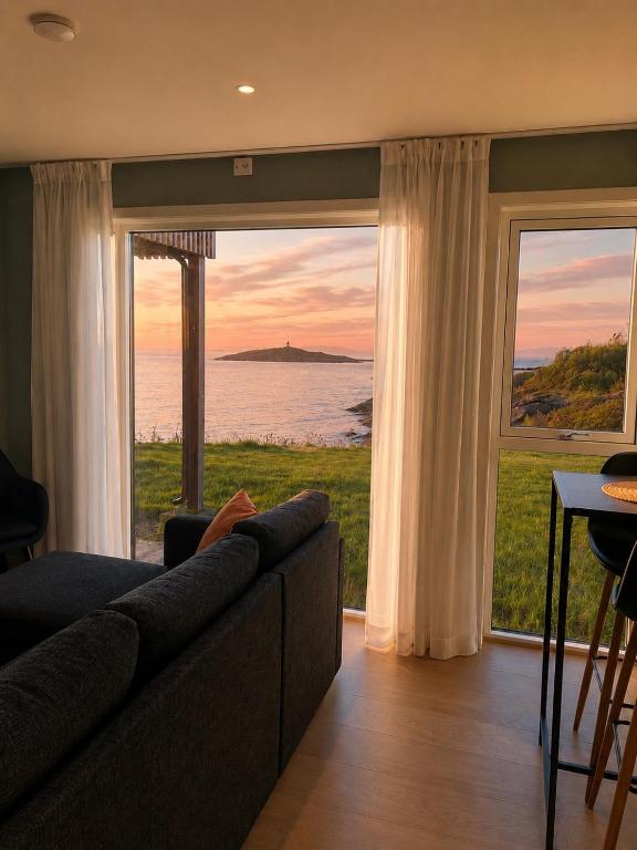a living room with a couch and a view of the ocean at Reine Sea Apartment in Moskenes