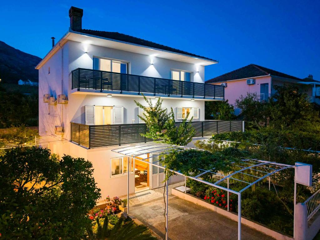 a large white house with a staircase leading up to it at Apartments Marina in Orebić