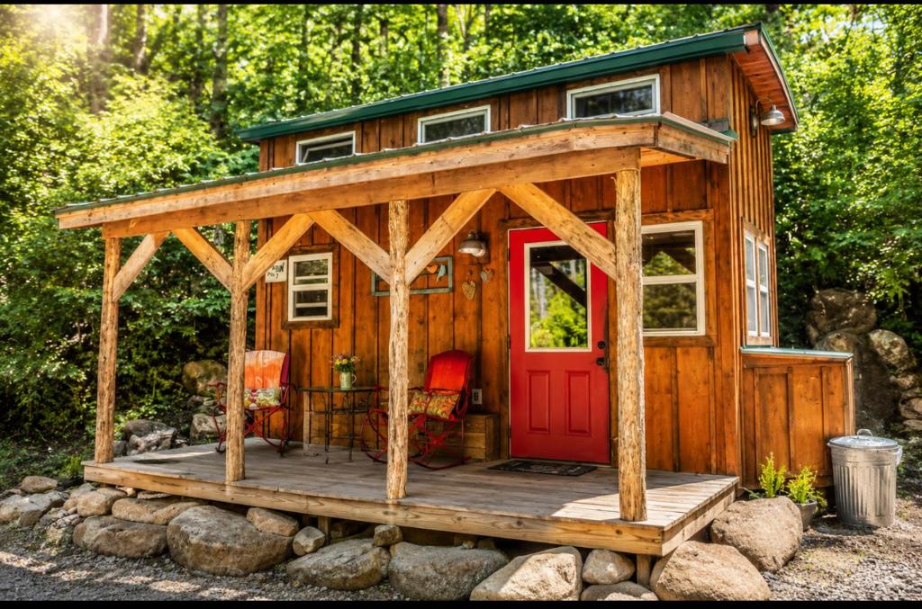 a cabin with a red door on a wooden deck at Peaceful Forest Tiny Home in Newport