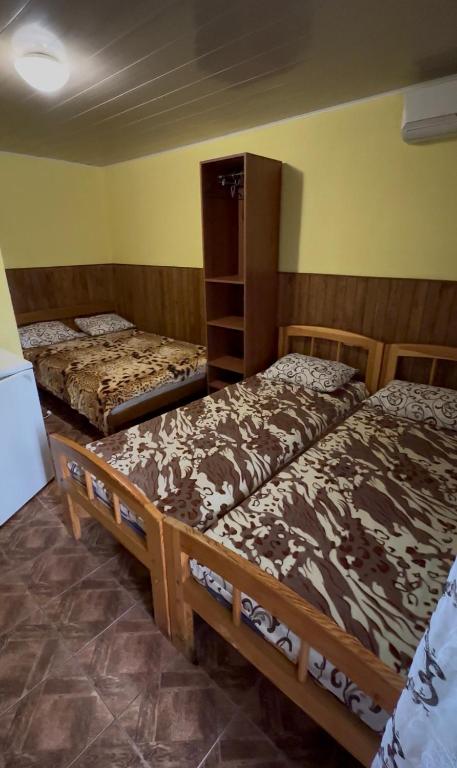two beds in a room with yellow walls at Дача in Kurortne