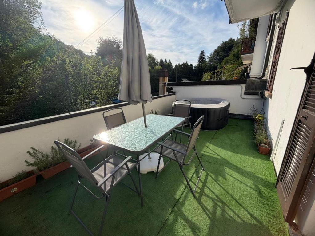 a table and chairs on a balcony with an umbrella at Bellagio, Como Lake Breva - Como Lake in Bellagio