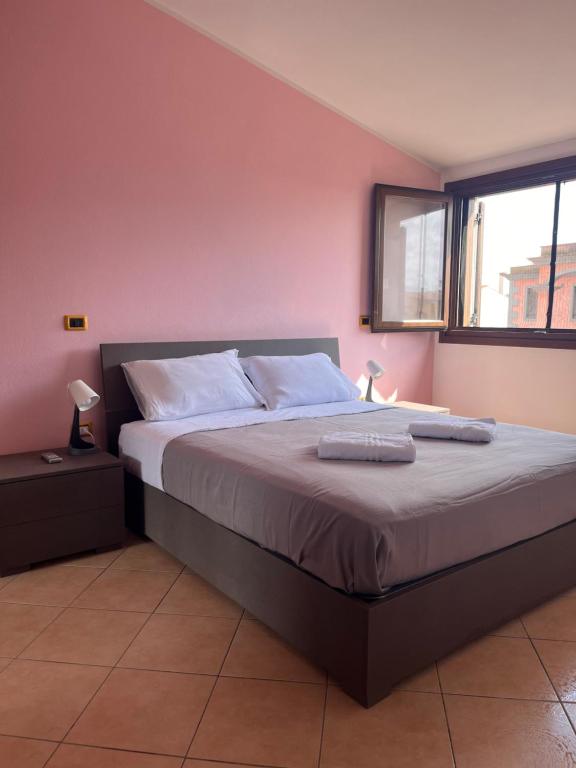 a bedroom with a bed with white sheets and a window at Alma's house in Donigala Fenughedu
