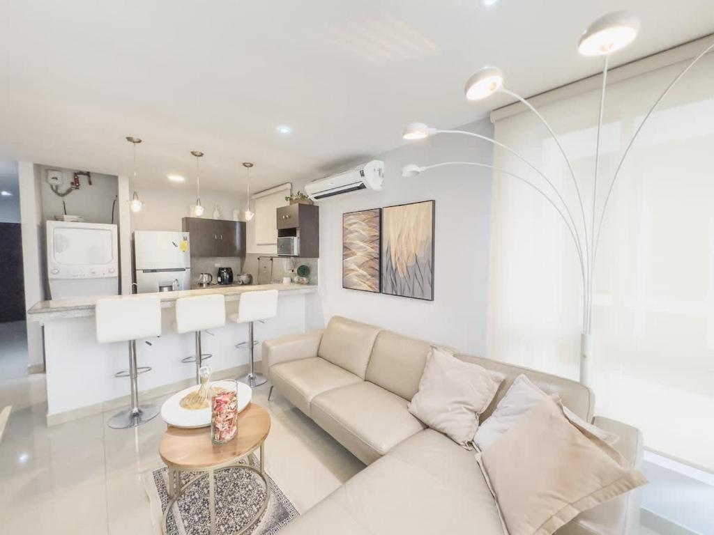 a white living room with a couch and a table at Amazing apartment near US Consulate in Guayaquil